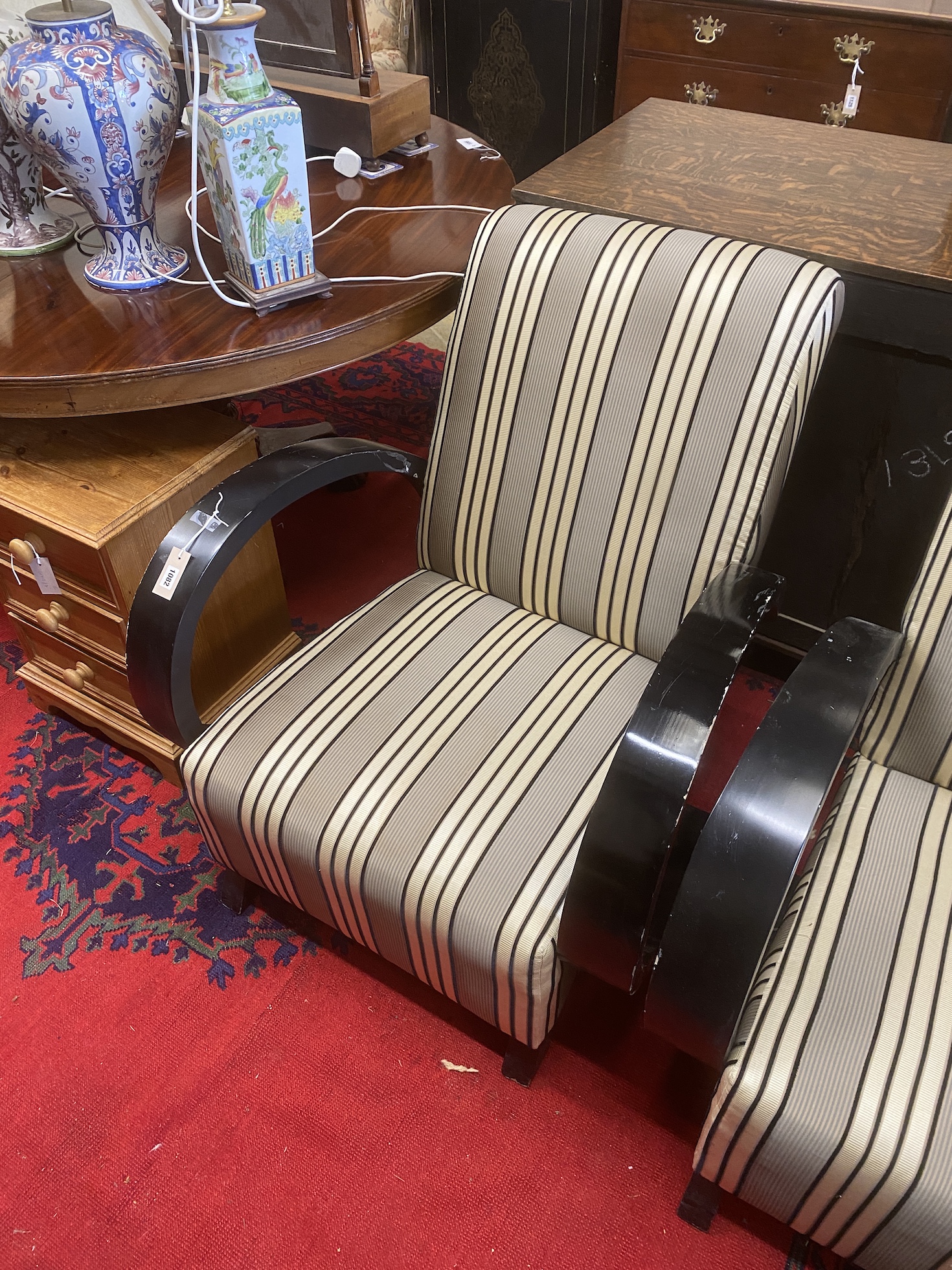 A pair of Deco style ebonised upholstered armchairs, width 78cm, depth 92cm, height 87cm